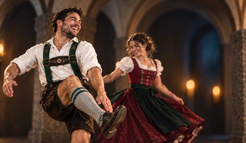 Tanzpaar in Tiroler Tracht beim Schuhplattln im Gewölbe – Tiroler Abend in der Ritterkuchl